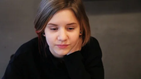 Face young girl uses computer with interest while sitting at the table child Stock Footage 99253655