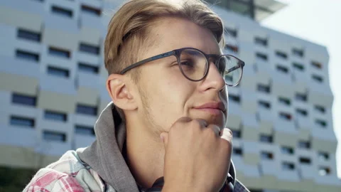 Face Of Young Handsome Guy. Serious Look. He Is On The Street With Headphones Stock Footage 143345455