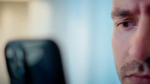Face of a young male looking at his smartphone so close Stock Footage 317819189