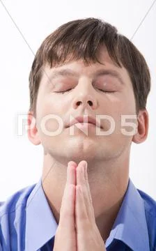 Face of young man with closed eyes and his hands keeping in touch beneath his ch Stock-Fotos