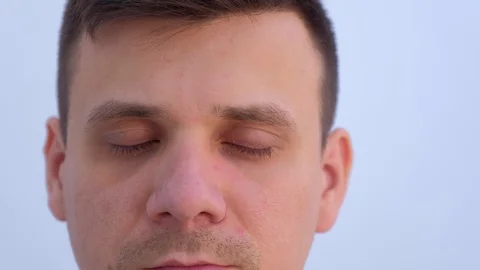Face of young man on light background with small papillomas on eyelids. Stock Footage 123336901
