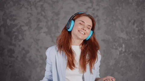 Face young red headed female with earphones dances Stock Footage 191924836