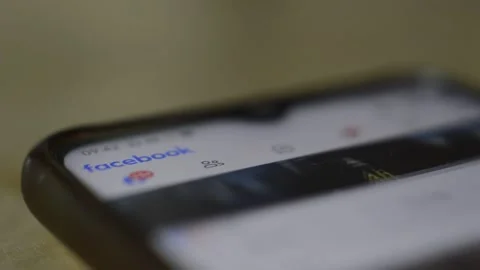 Facebook logo icon scroll on the phone display. facebook social network app. Stock Footage 254065659