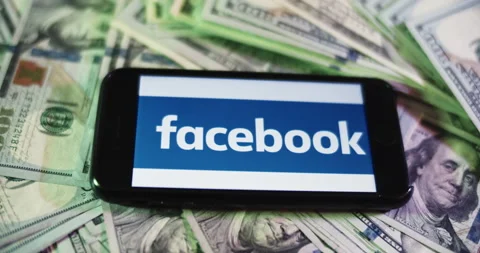 Facebook Logo on iphone surrounded by $100 Bills. Facebook Profits Layout. Stock Footage 169008191