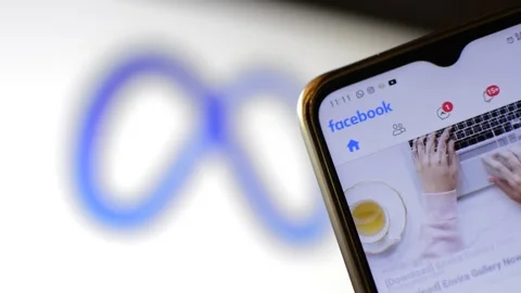 Facebook social network app scroll in the phone with meta icon on background. Video stock 222741994