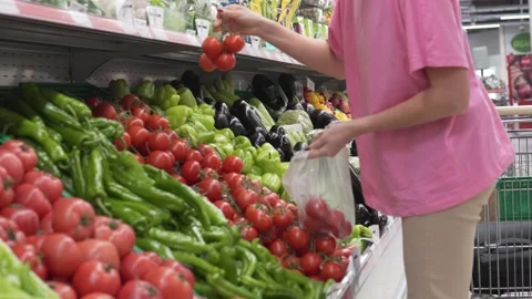 A faceless customer chooses tomatoes on a twig in a supermarket Stock Footage 223662267