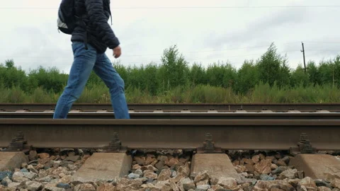 Faceless guy with backpack walks on rails Video stock 161657294