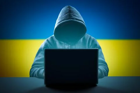Faceless hooded anonymous computer hacker on Ukrainian flag background. Inter Stock-Fotos