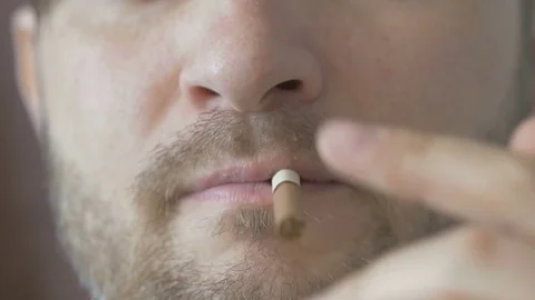 Faceless man lighting a cigarette in the room Video stock 74208414