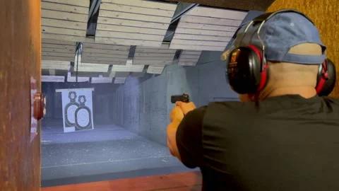 Faceless man shoots at a paper target in the man shape in shooting range Stock Footage 194440749