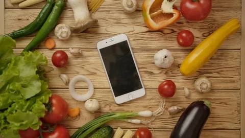 Faceless man taking smartphone from table with vegetables Stock Footage 119970040