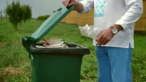 A faceless white man throws recyclable plastic bottles into a trash can. Stock Footage 198679826