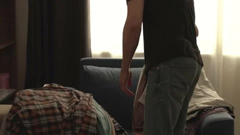 Faceless. The young man declutters his wardrobe. Stock Footage 199195207
