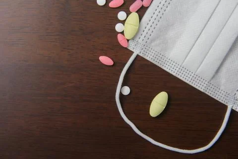 Facemask and pill on the table Stock Photos