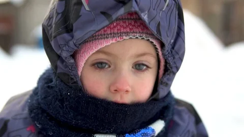 Faces of a child close-up outdoors in winter. In the cold winter, the child is Stock Footage 122255845