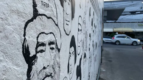 Faces mural artwork painted on white wall public near street. Thailand Stock Footage 252160943
