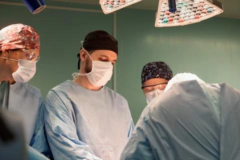 Faces of the team of surgeons, operation, modern surgery, light of operating Stock Photos