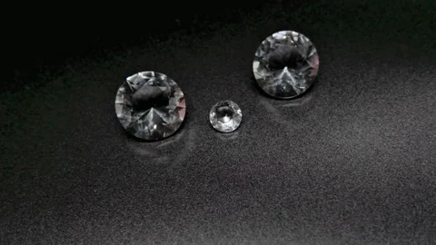 Faceted Gemstones Sparkling on Black Surface with Reflections 動画素材 343635172