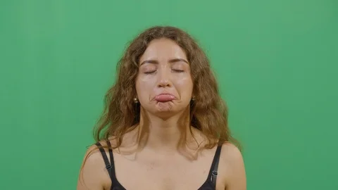Facial expression of a woman pouting studio isolated shot against green screen Stock Footage 117713495