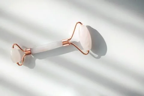 Facial jade massage roller or gua sha over the white background. Stock Photos