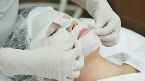 Facial mask applying using brush in Beauty salon. Spa Beautician applying Facial Video stock 69740143