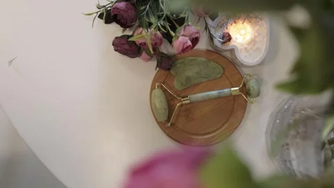 Facial Massage Jade Roller on a Table with Flowers Stock Footage 300480730
