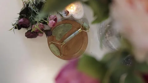 Facial Massage Jade Roller on a Table with Flowers Stock Footage 300480749