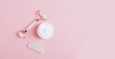 Facial massage set roller scraper guasha pink background. Stock Photos