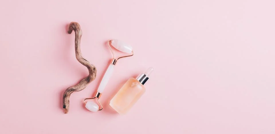 Facial massage set roller scraper guasha pink background. Stock Photos