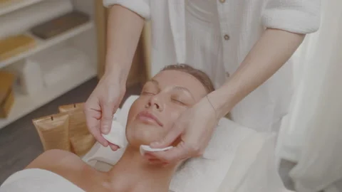 Facial massage with smoothing movements,application of tonic with cotton pads. Stock Footage 197596335