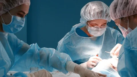 Facial plastic surgery. Teamwork with nurse and surgeon performing surgery in Stock Footage 121889629
