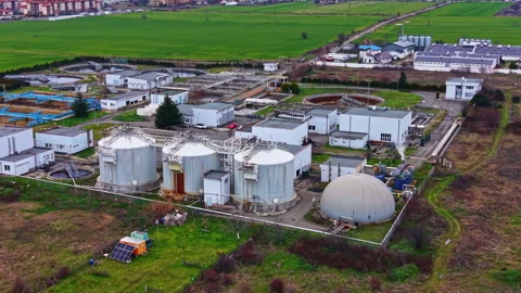 Facilities process waste near the fields with green grass and buildings in the Stock Footage 331905453