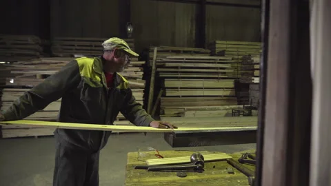 Facility woodworker is loading lumber boards on the wood processing Machine Stock Footage 171970375
