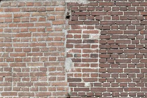 Facing bricks in a repaired wall in a dark red color in chain bond. Stock Photos