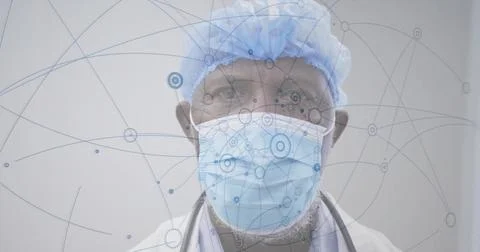 Facing camera doctor posing in clinic room, wearing mask, lab coat, stethoscope, Stock Photos