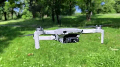Facing Closeup Shot of Drone Hovering in Green Park Stock Footage 311936443