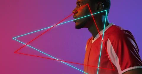 Facing right man wearing red jersey in studio, cyan neon triangles on magenta Stock Photos