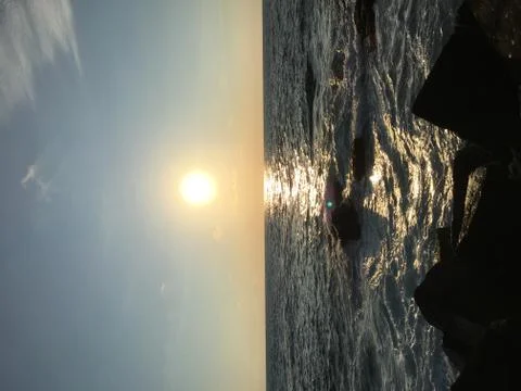 Facing the sun when its going down at the sea Stock Photos