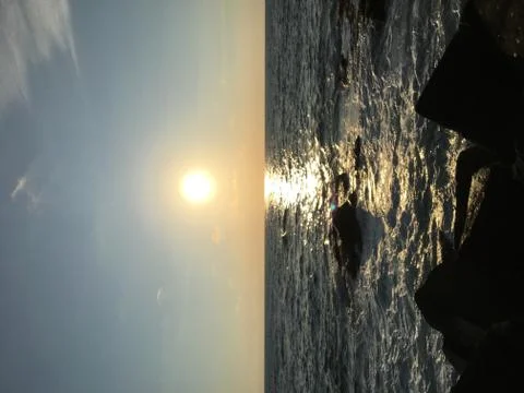 Facing the sun when its going down at the sea Stock Photos