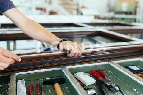 Factory for aluminum and PVC windows and doors production. Manual worker asse Stock Photos