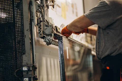 Factory for aluminum and PVC windows and doors production. Manual worker asse Stock Photos