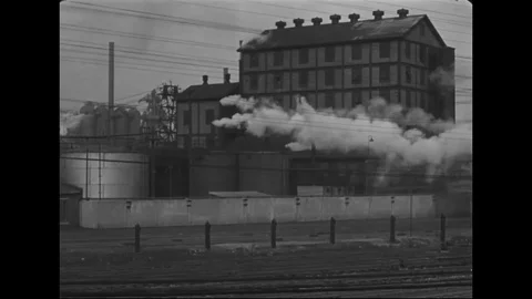 Factory and steam engine train spews huge smoke clouds - 1939 Vídeos de archivo 101914542