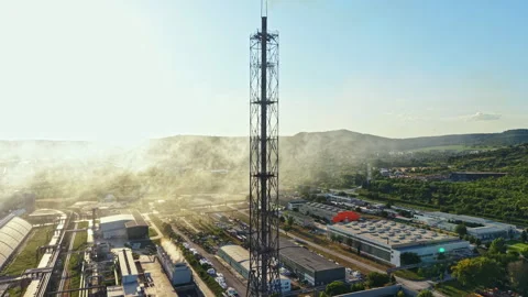 Factory area with large tower and buildings under clear blue sky during late Stock Footage 341579244