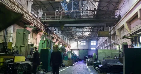 Factory beam crane moves on top of a large workshop. Workers at turning lathes Stock Footage 80190685