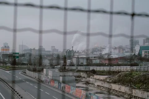   Factory Behind Barbed Wire and Smoke Rising to the Sky Stock Photos