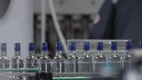 Factory for bottling vodka. Working machine with conveyor line for production of Stock Footage 127780752