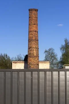 Factory brick pipe. A brick chimney rises against the sky. Stock Photos