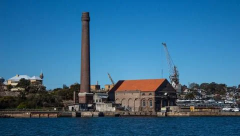 Factory brick smoke stack at historic dockyard and boat storage with crane 写真素材