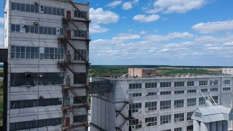 Factory building on a background of green field Stock Footage 125777071