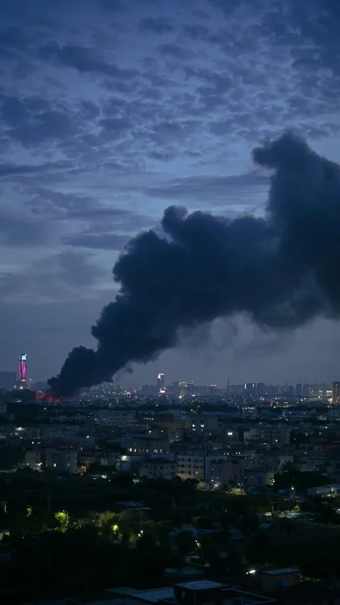 A factory catched a fire with lots dark smoke in sunset time vertical Stock Footage 248273401